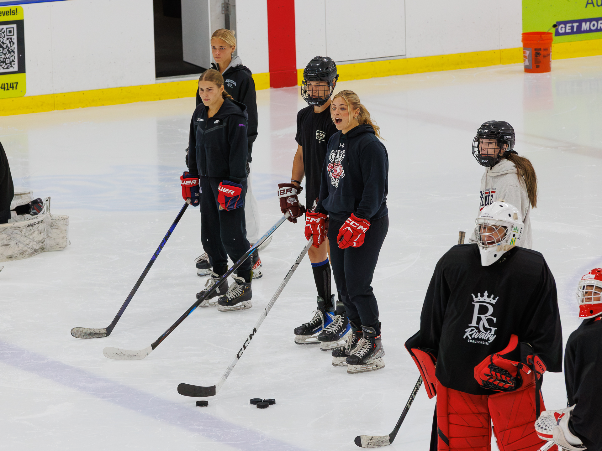 Coach leading a group of goalies on the ice