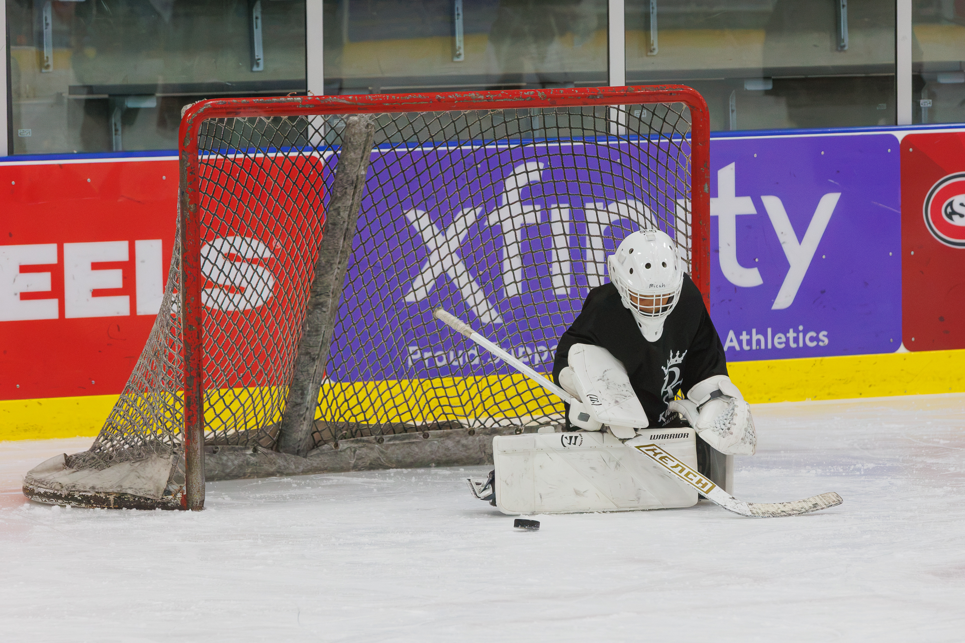 Young goalie tracking the puck in front of the net